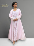 Model wearing a light pink Morrocan Kaftan with a matching jacket against a gray background.