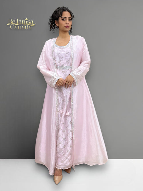Model wearing a light pink Morrocan Kaftan with a matching jacket against a gray background.